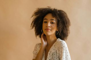 Portrait of a stylish young woman in a polka dot dress, embodying elegance and confidence.