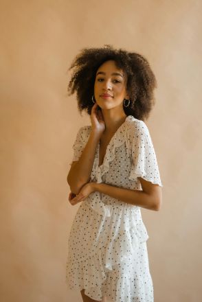 Portrait of a stylish young woman in a polka dot dress, embodying elegance and confidence.